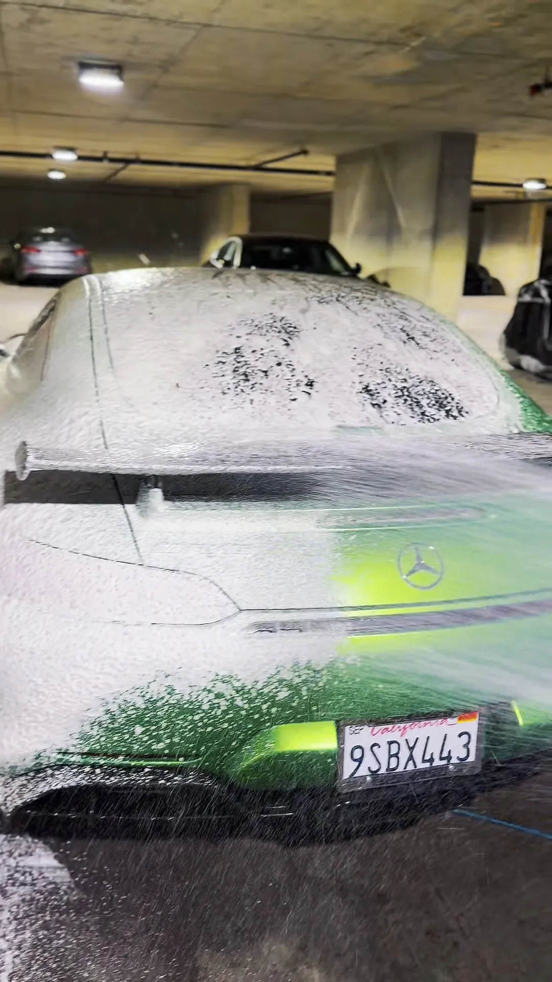 Rear view of a Mercedes-AMG GT covered in pre-wash foam