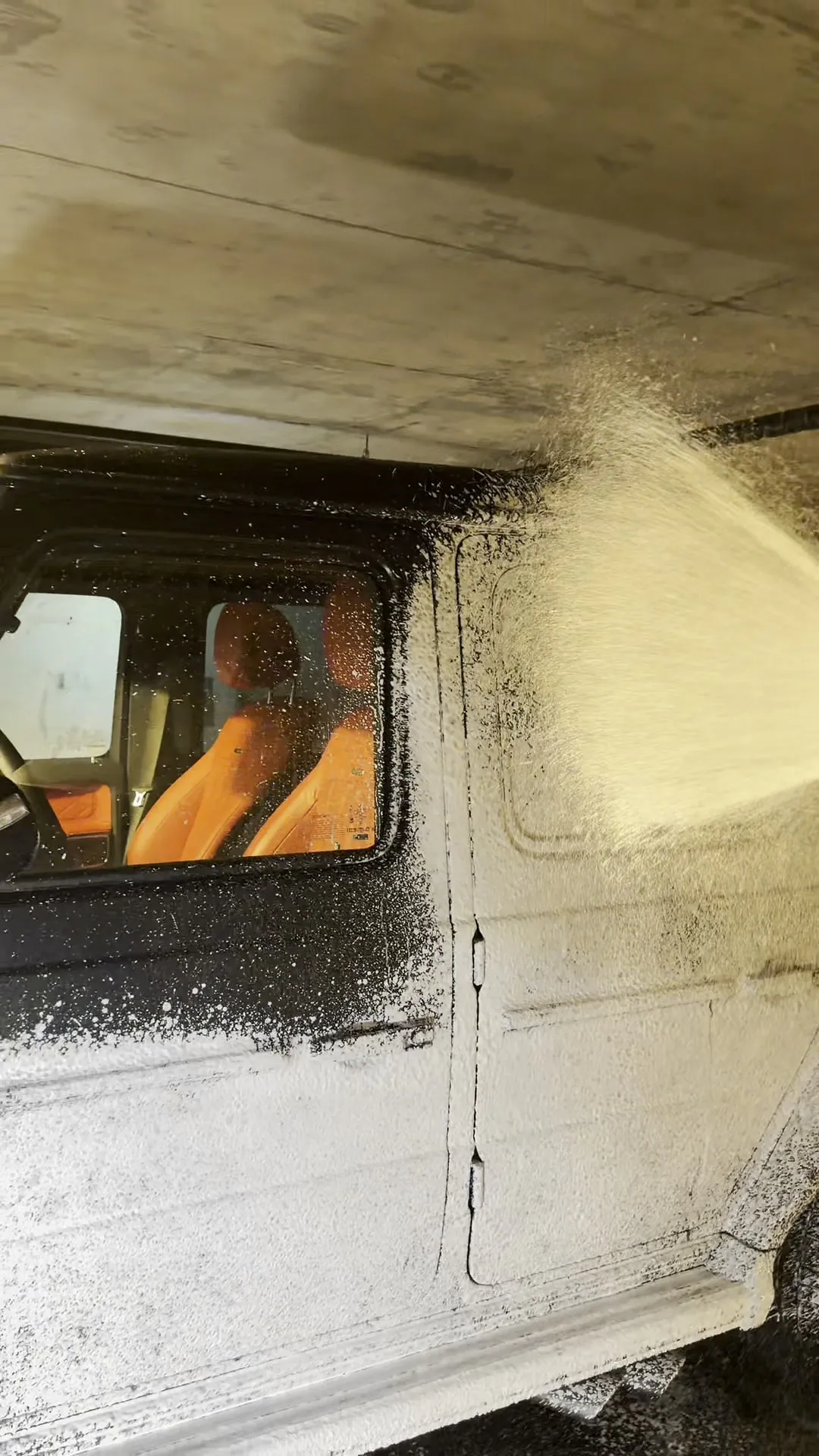 G-Wagon interior visible through a foam-covered window during exterior pre-wash